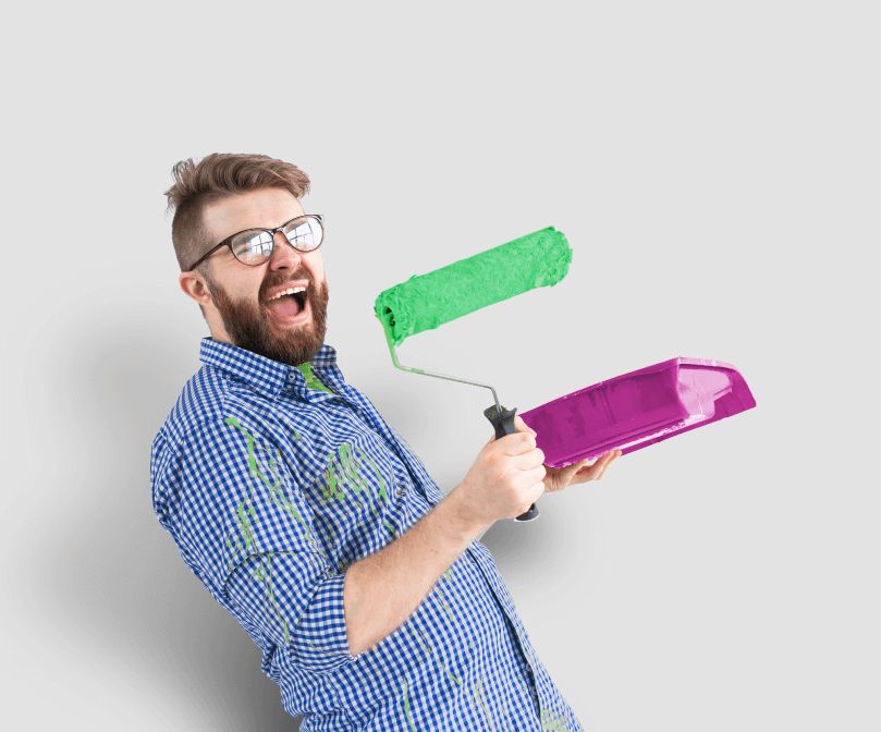Hombre feliz con rodillo de pintura y bandeja de pintura remodelando su casa con el dinero del pr�stamo